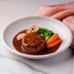 Une photographie de Hambagu, le steak Japonais, surmonté de sauce demi-glace japonaise
