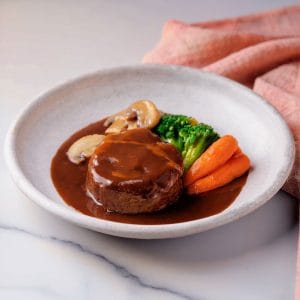Une photographie de Hambagu, le steak Japonais, surmonté de sauce demi-glace japonaise