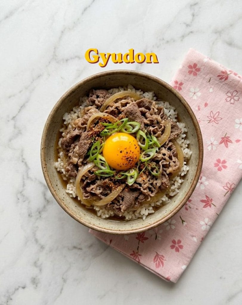 Un bol de Gyudon traditionnel avec du riz, du boeuf émincé aux oignons, un jaune d'oeuf cru au centre et des oignons verts émincés.