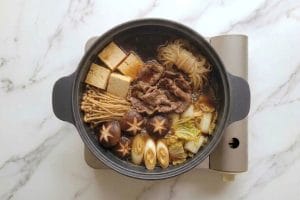 Marmite en fonte de sukiyaki en cours de repas avec du dashi prêt à diluer la sauce warishita.