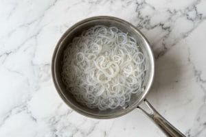 Blanchiment des shirataki de konjac dans une casserole d'eau bouillante.