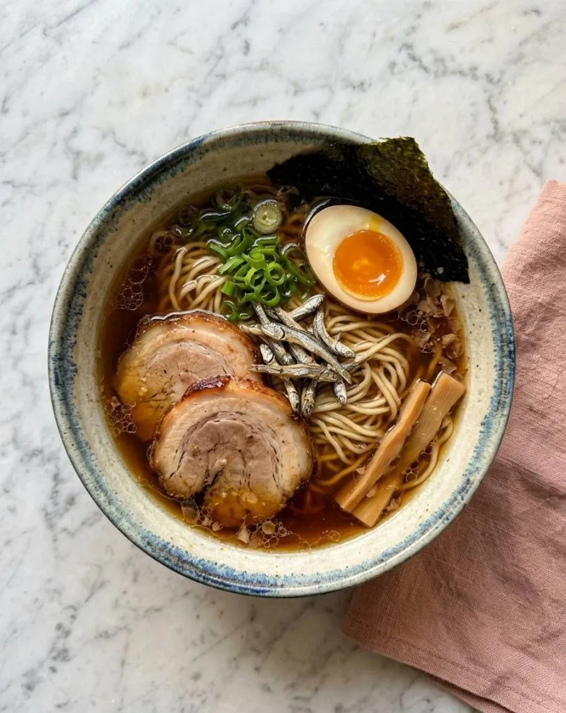 Shoyu Tare : la Recette de la Base Sauce Soja du Ramen 14 Le Niboshi Shoyu Ramen est une spécialité japonaise de ramen caractérisée par un bouillon mariant de la sauce soja (shoyu) et des petites sardines séchées (niboshi), ce qui lui confère une saveur marine unique riche en umami.