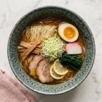 Le shio ramen de Hakodate : le ramen le plus épuré du Japon. Un bouillon chintan translucide, rehaussé de shio tare, chashu de porc et une touche d'agrumes.