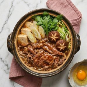Sukiyaki Kansai : méthode traditionnelle de cuisson où l'on saisit d'abord la viande de bœuf avec du sucre et de la sauce soja dans une poêle chaude avant d'ajouter les légumes.