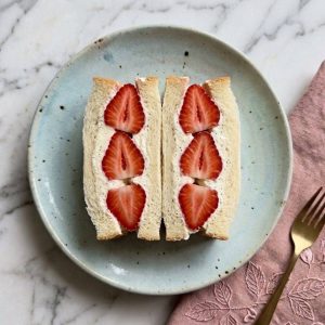 L'ichigo sando est un sandwich japonais sucré composé de pain de mie moelleux (shokupan), de crème fouettée légère et de fraises fraîches.