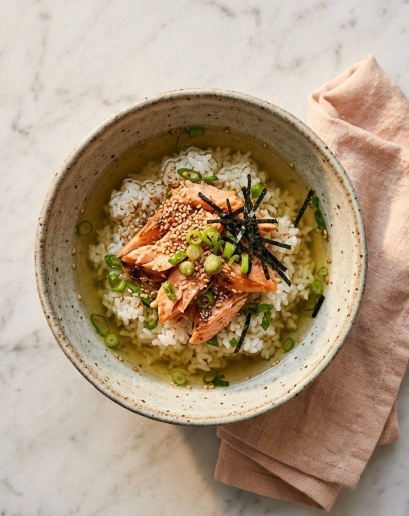 L'ochazuke (ou chazuke) est un plat traditionnel japonais réconfortant et rapide qui consiste à verser du thé vert chaud ou un bouillon dashi sur un bol de riz blanc cuit, le tout agrémenté de diverses garnitures salées.