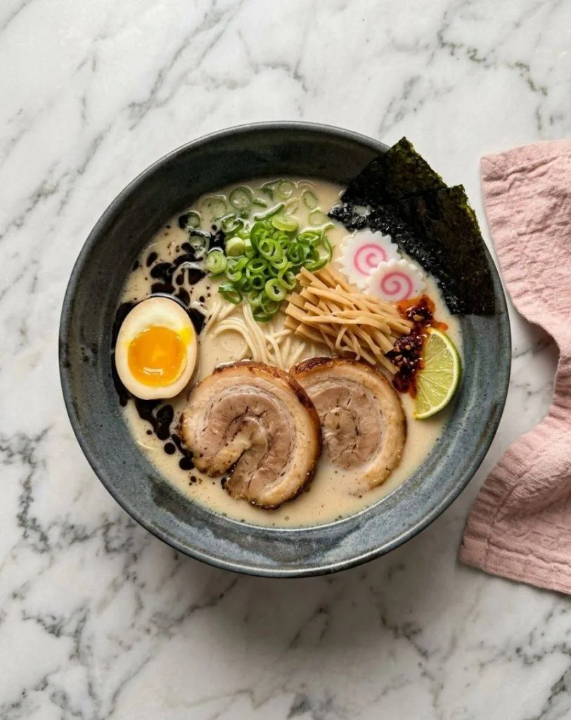 Le Tonkotsu ramen est une spécialité de ramen japonaise originaire de Kurume (préfecture de Fukuoka), célèbre pour son bouillon blanc, riche et crémeux obtenu en faisant bouillir des os de porc à feu vif pendant de nombreuses heures (jusqu'à 12 ou 18 heures).