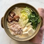 Le Tonyu Nabe (豆乳鍋) est une fondue japonaise (hot pot) réconfortante préparée dans un bouillon crémeux à base de lait de soja (tōnyū) et de dashi, souvent aromatisé au miso et au sésame.